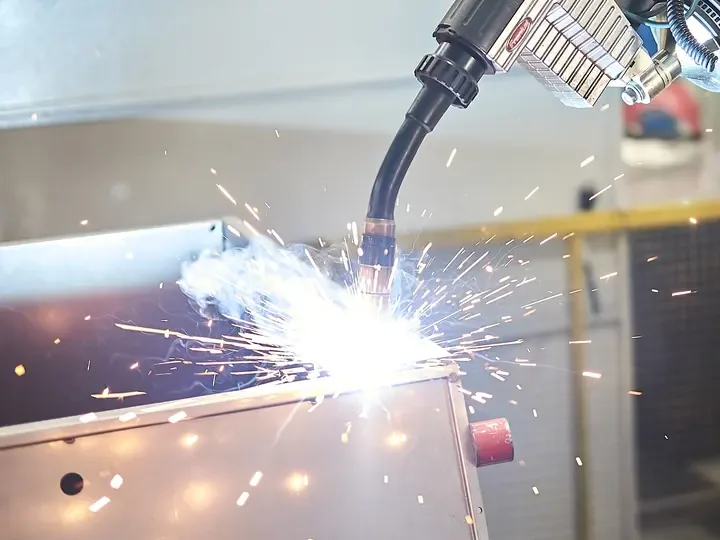 Robotic MIG welding arc on a sheet metal enclosure